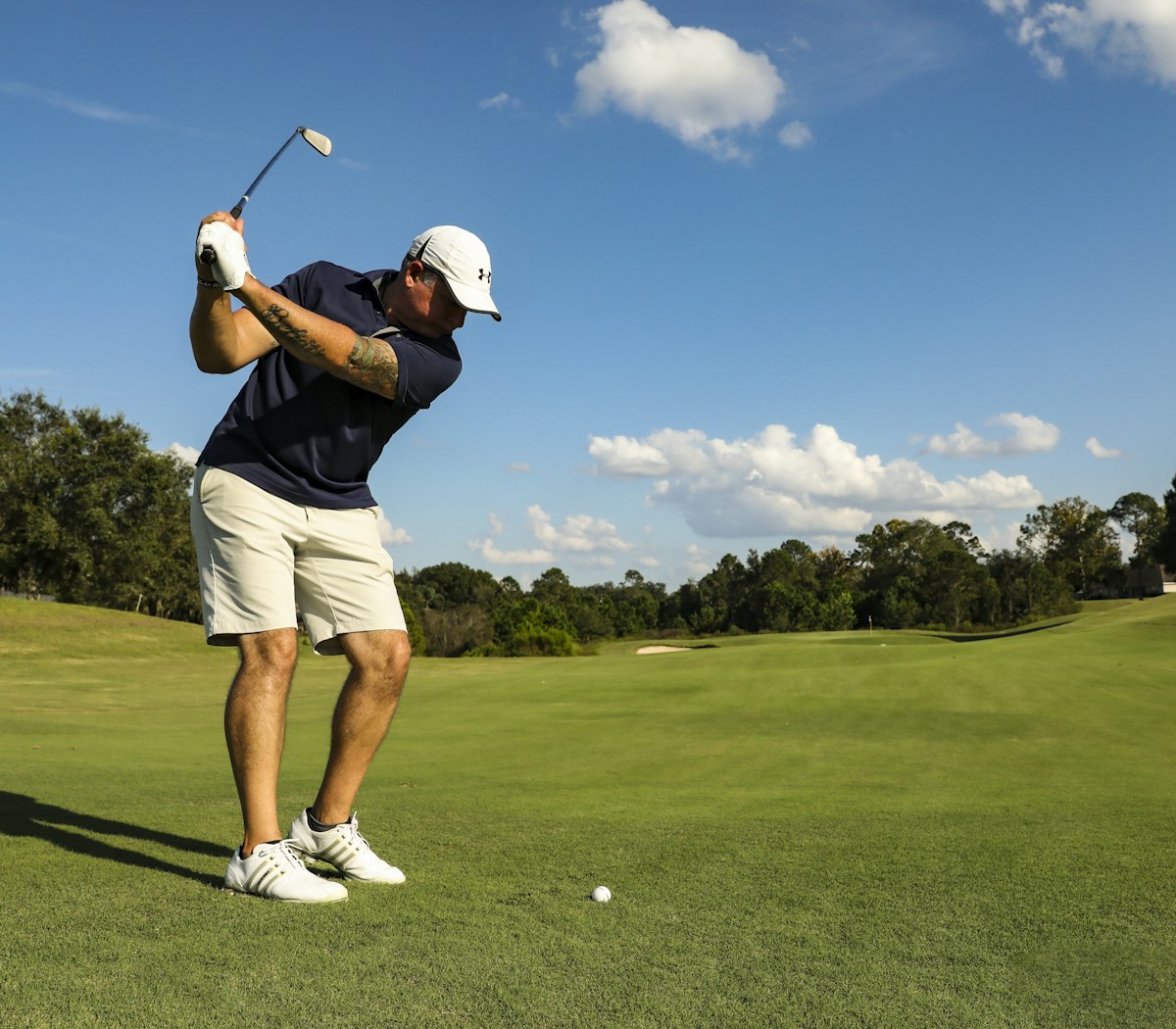 Golfer swinging on course